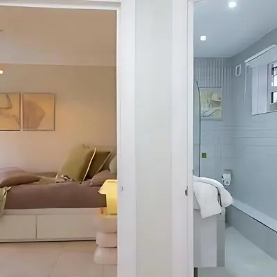 a room with a bed and a glass door at Elegant, Victorian End of Terrace Town House in Southend-on-Sea