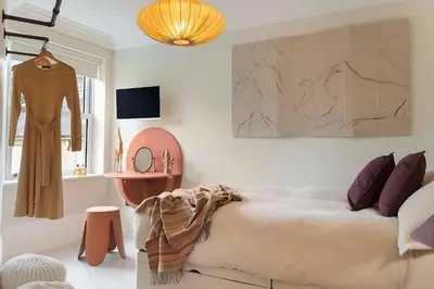 a bedroom with a bed and a dressing table at Elegant, Victorian End of Terrace Town House in Southend-on-Sea