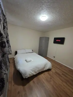 a bedroom with a white bed and a sign on the wall at Spacious Double Room in Basildon Essex in Basildon