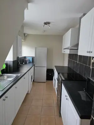 a kitchen with white cabinets and a white refrigerator at Spacious Double Room in Basildon Essex in Basildon