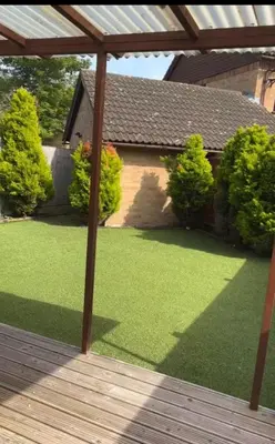 a yard with grass and a wooden deck at Amazing studio room in a beautiful house in Stanford le Hope