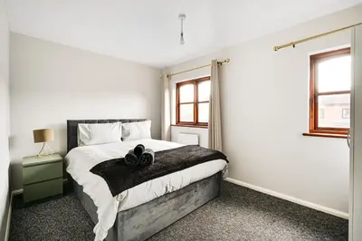 a bedroom with a large bed and a window at Stunning 7-Bed, 6-Bath Home in Essex with Free Parking in Clacton-on-Sea