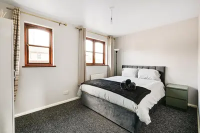 a bedroom with a bed with two black shoes on it at Stunning 7-Bed, 6-Bath Home in Essex with Free Parking in Clacton-on-Sea