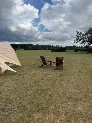 two chairs and a tent in a field at Farmview Bell Tent in Messing