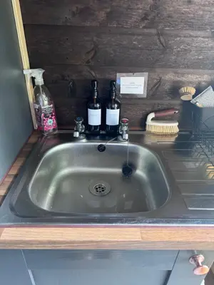 a kitchen sink with two bottles of wine on it at Farmview Bell Tent in Messing