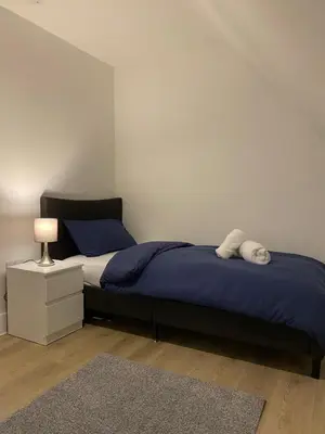 a bedroom with a bed with blue sheets and a lamp at Modern Stay - Walk to Everything 6 in Ipswich