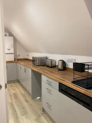 a kitchen with white cabinets and a wooden counter top at Modern Stay - Walk to Everything 6 in Ipswich