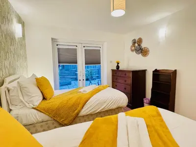 a bedroom with two beds and a window at Spacious 2 Bedroom Sleeps 4 with WiFi & Garden in Cambridge