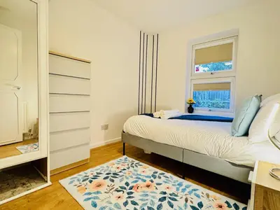 a bedroom with a bed with a window and a rug at Spacious 2 Bedroom Sleeps 4 with WiFi & Garden in Cambridge