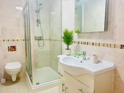 a bathroom with a sink and a shower and a toilet at Spacious 2 Bedroom Sleeps 4 with WiFi & Garden in Cambridge