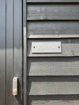 a wooden door with a sign on it at The Old Stable in Messing