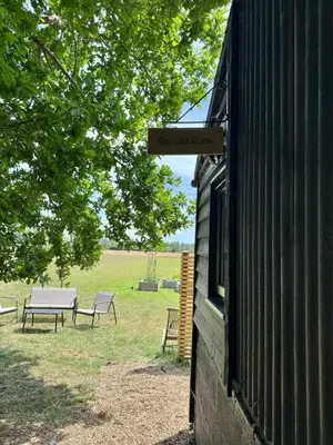 a sign on the side of a building with two benches at The Old Stable in Messing
