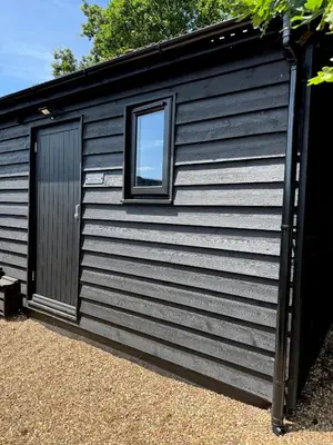 a black shed with a window on the side at The Old Stable in Messing