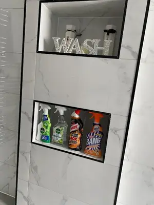 a shower stall with three shelves of cleaning products at Two double bedroom self contained Retreat in Thundersley