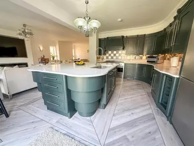 a large kitchen with green cabinets and a large island at Oceanfront 4BR Beach Retreat in Holland-on-Sea