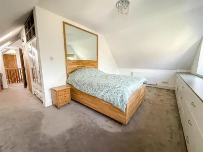 a bedroom with a bed and a large mirror at Oceanfront 4BR Beach Retreat in Holland-on-Sea