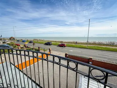 a view of the ocean from a balcony of a road at Oceanfront 4BR Beach Retreat in Holland-on-Sea