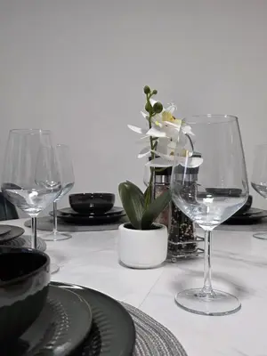 a table with wine glasses and a plant on it at Entire 3-Bed Home, 5 mins to City Centre, Sleeps 6, 2 Free Parking in Colchester