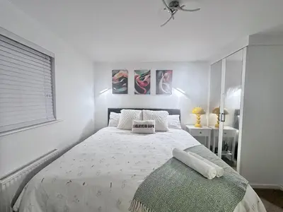 a white bedroom with a bed and a window at Entire 3-Bed Home, 5 mins to City Centre, Sleeps 6, 2 Free Parking in Colchester