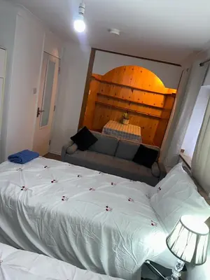 a bedroom with a large bed and a couch at Clayburn Spacious Twin Bed Large Room in Basildon