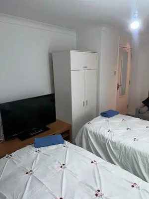 a room with two beds and a flat screen tv at Clayburn Spacious Twin Bed Large Room in Basildon