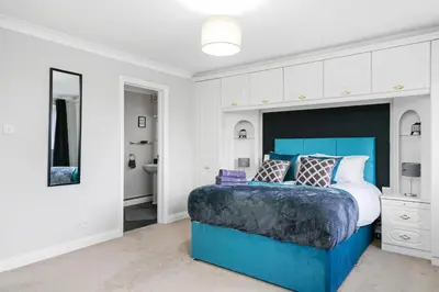 a bedroom with a blue bed and white cabinets at Detached 6 Bedroom Cambridgeshire Abode - Pets in Whittlesford