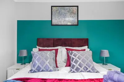 a bedroom with a bed with a green wall at Detached 6 Bedroom Cambridgeshire Abode - Pets in Whittlesford