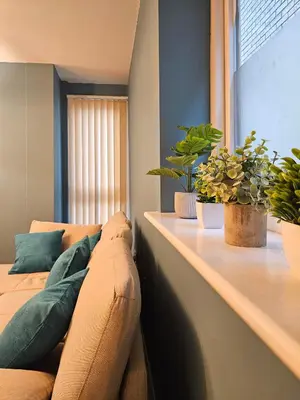 a living room with a couch and two potted plants at Gorgeous Flat with Charming Patio in Cambridge
