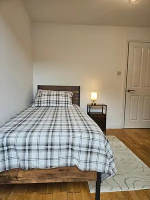 a bedroom with a bed with a checkered blanket at Gorgeous Flat with Charming Patio in Cambridge