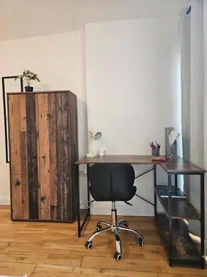 a desk with a chair next to a wooden cabinet at Gorgeous Flat with Charming Patio in Cambridge