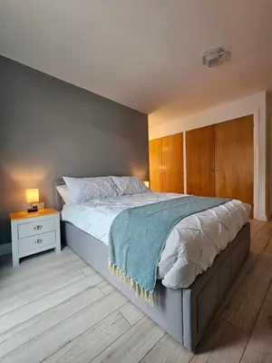 a bedroom with a large bed and a night stand at Gorgeous Flat with Charming Patio in Cambridge