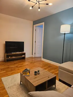 a living room with a coffee table and a flat screen tv at Gorgeous Flat with Charming Patio in Cambridge