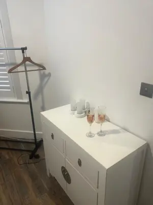a table with two wine glasses and a tripod at Southend Luxe Retreat in Southend-on-Sea