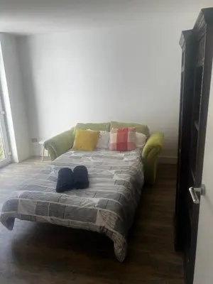 a bed with two shoes on it in a room at Southend Luxe Retreat in Southend-on-Sea