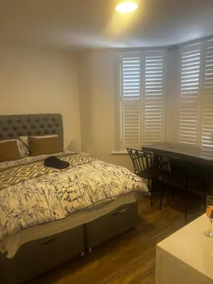 a bedroom with a bed and a desk and a table at Southend Luxe Retreat in Southend-on-Sea
