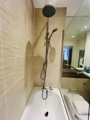 a bathroom with a shower and a tub and a sink at 503 Focus Apartments in Ipswich