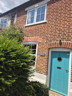 a brick house with a blue door at Lime Kiln Quay Cottage in Woodbridge