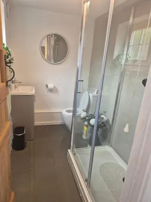 a bathroom with a shower and a toilet at Lime Kiln Quay Cottage in Woodbridge