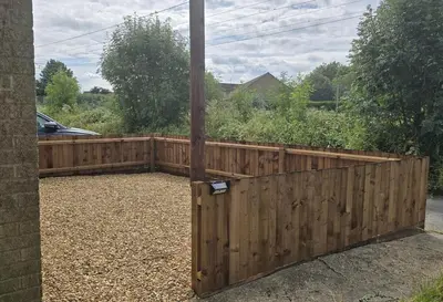 a wooden fence with a pole in a yard at Grace's Place in Littleport in Littleport