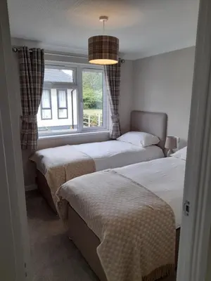 a bedroom with two beds and a window at Pullman Lodge in Glemsford