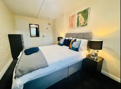 a bedroom with a large white bed and a lamp at Spacious 6 Bedroom House Basildon with Free Parking for Contractors and Business - Free Parking l sleeps 12 in Basildon