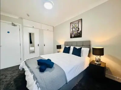 a bedroom with a large white bed with blue pillows at Spacious 6 Bedroom House Basildon with Free Parking for Contractors and Business - Free Parking l sleeps 12 in Basildon