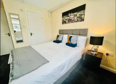 a bedroom with a large white bed and a lamp at Spacious 6 Bedroom House Basildon with Free Parking for Contractors and Business - Free Parking l sleeps 12 in Basildon