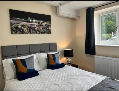 a bedroom with a bed and a painting on the wall at Spacious 6 Bedroom House Basildon with Free Parking for Contractors and Business - Free Parking l sleeps 12 in Basildon