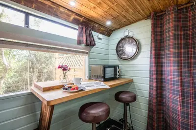 a tiny house with a desk and a window at The Bus Stop, Thornham Magna in Thornham Magna