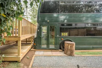 a green bus parked next to a wooden deck at The Bus Stop, Thornham Magna in Thornham Magna
