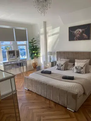 a bedroom with a large bed in a room at Southend Apartment With Parking, Private Garden and Beach Side Location in Southend-on-Sea