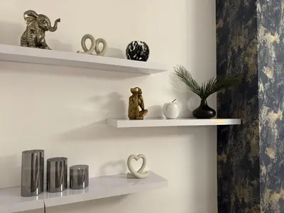 a room with white shelves with sculptures on them at Southend Apartment With Parking, Private Garden and Beach Side Location in Southend-on-Sea