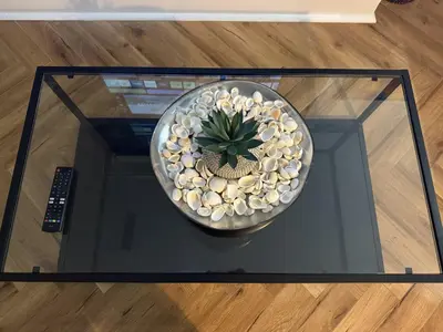 a glass table with a bowl with a plant on it at Southend Apartment With Parking, Private Garden and Beach Side Location in Southend-on-Sea