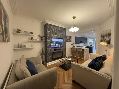 a living room with two couches and a television at Southend Apartment With Parking, Private Garden and Beach Side Location in Southend-on-Sea